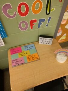Wall in classroom says "Cool off" over a desk